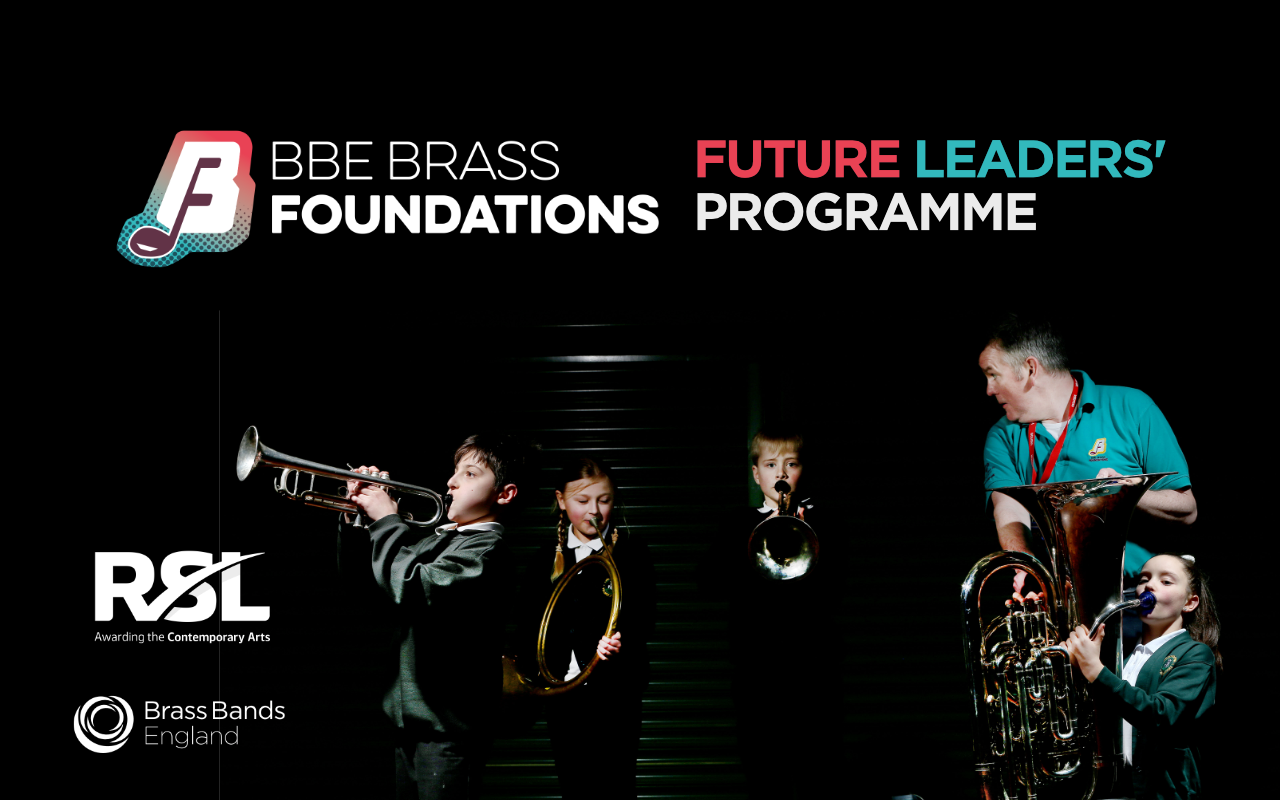 Group of boys and girls playing different brass instruments under very dark lighting - a music tutor wearing a bright green shirt looks over