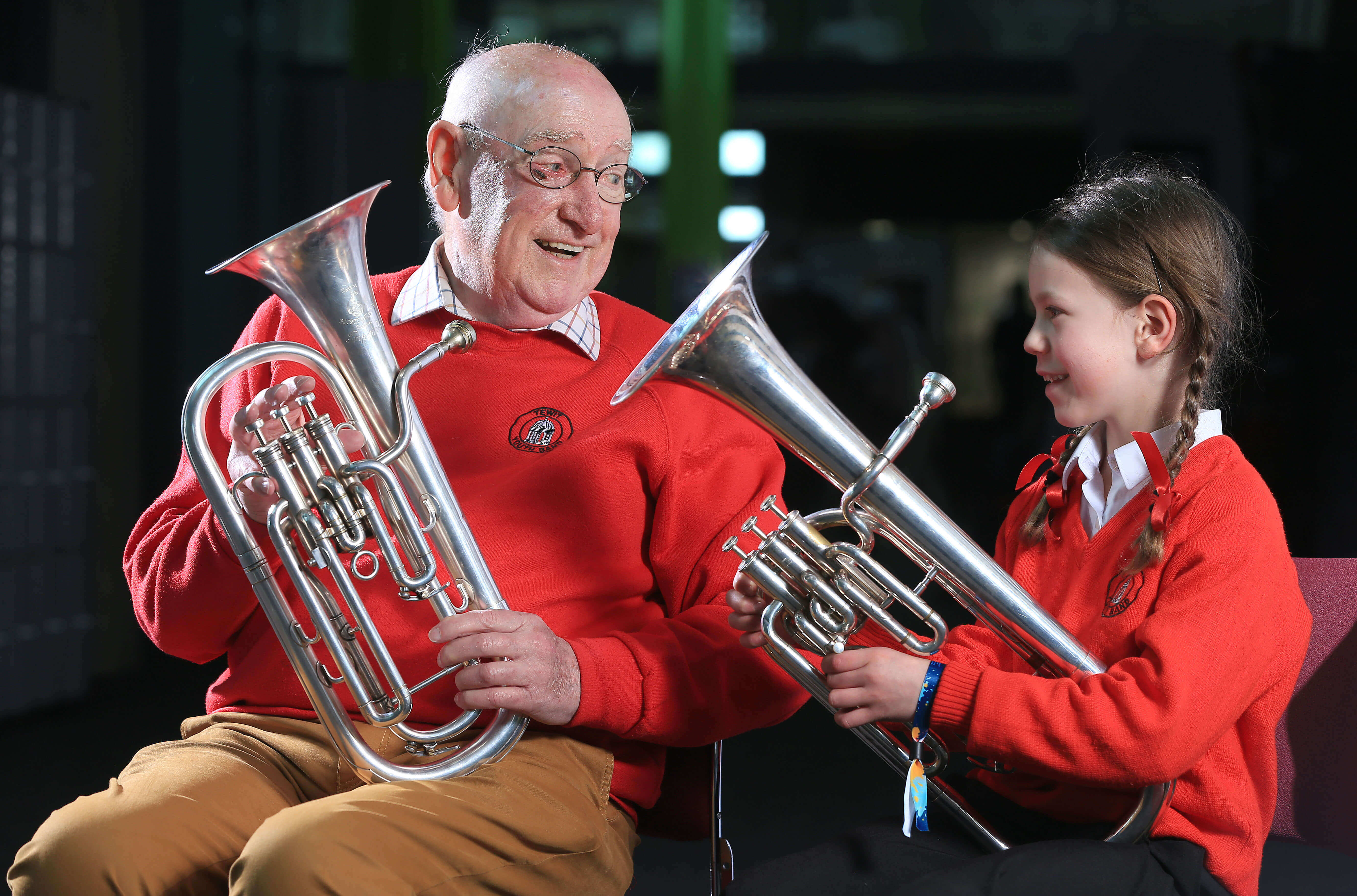 Older male with a young girl both holding a tenor horn