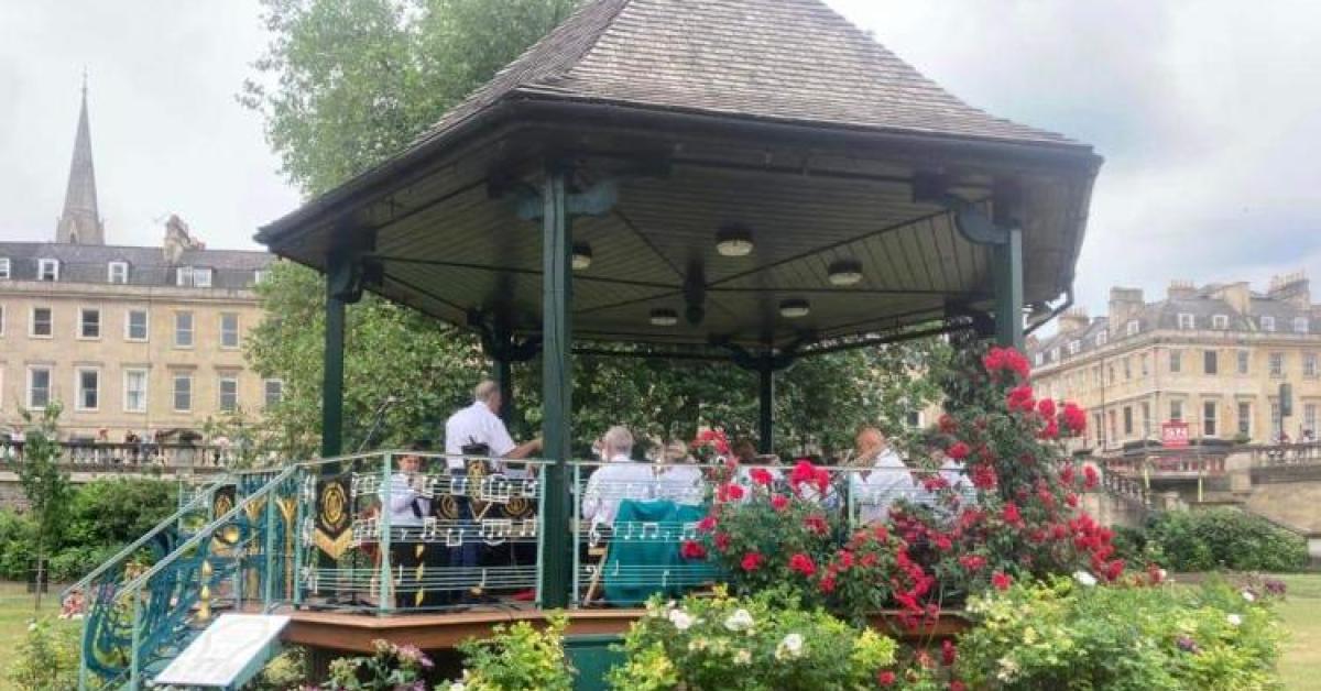A photo of a band stand in a garden with a brass band playing