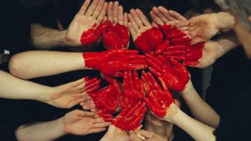 Collection of hands painted red and placed together to form a heart