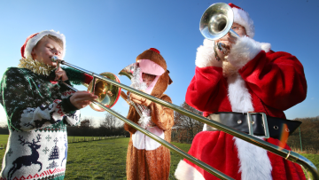 Children playing brass intruments in Christmas costumes