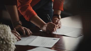 Someone signing a paper document