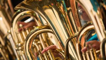 An up close photograph of a brass instrument being played