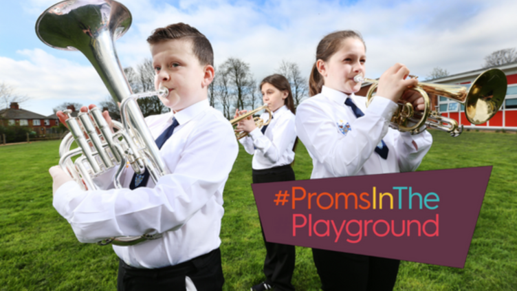 Three young players stand with their instruments. In the bottom right corner is written Proms in the Playground