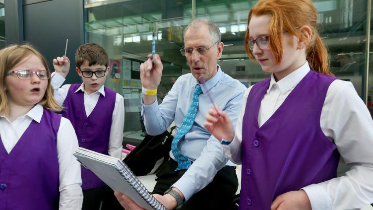 John Fricker from BBCA with 2 young girls and a boy conducting