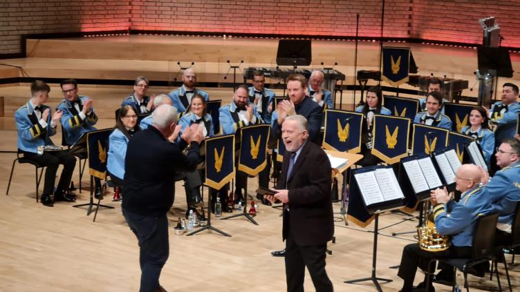 Paul Hindmarsh is presented with award in front of a brass band