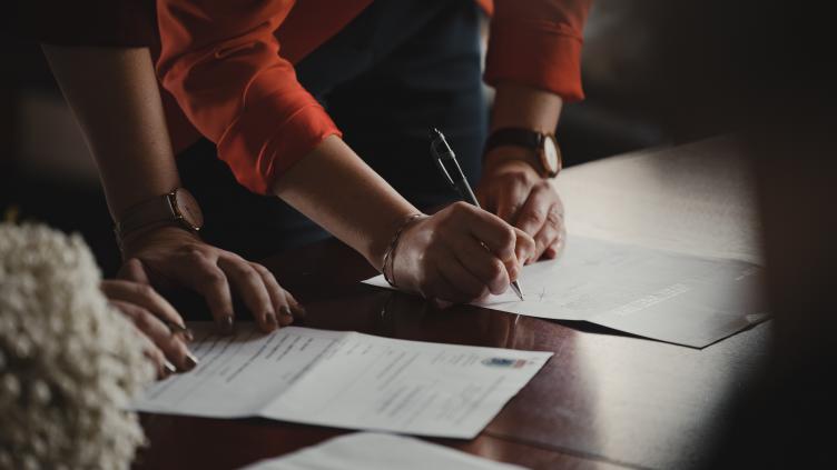 Someone signing a paper document